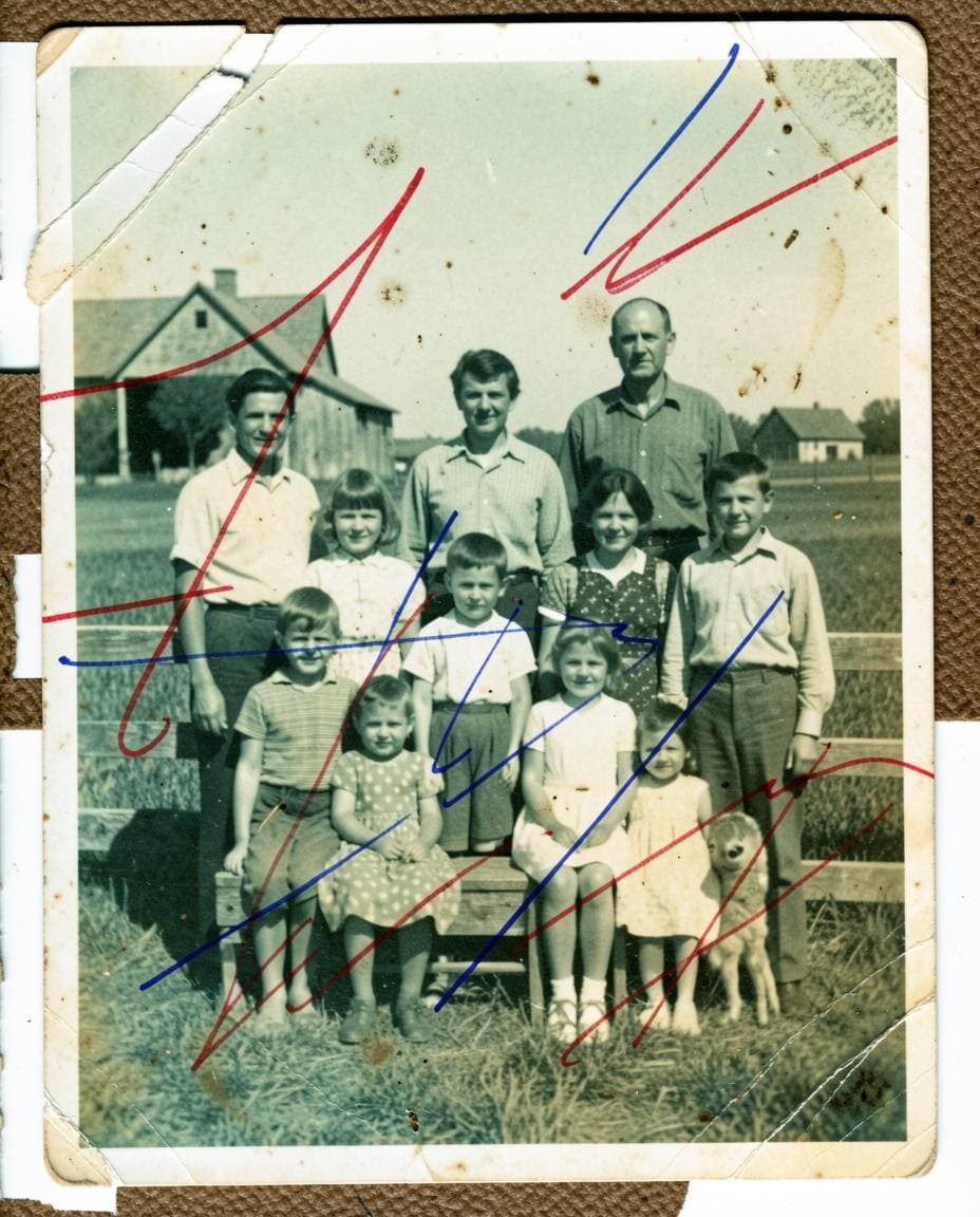 Yellowed and stained 1940s family photo from attic with water damage, brown stains, and worn edges